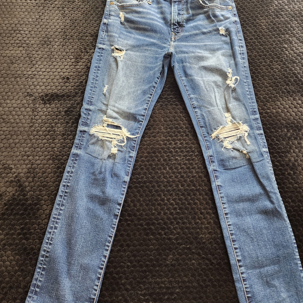 The American Eagle Slim Straight Blue Distressed Denim Jeans are a stylish and c